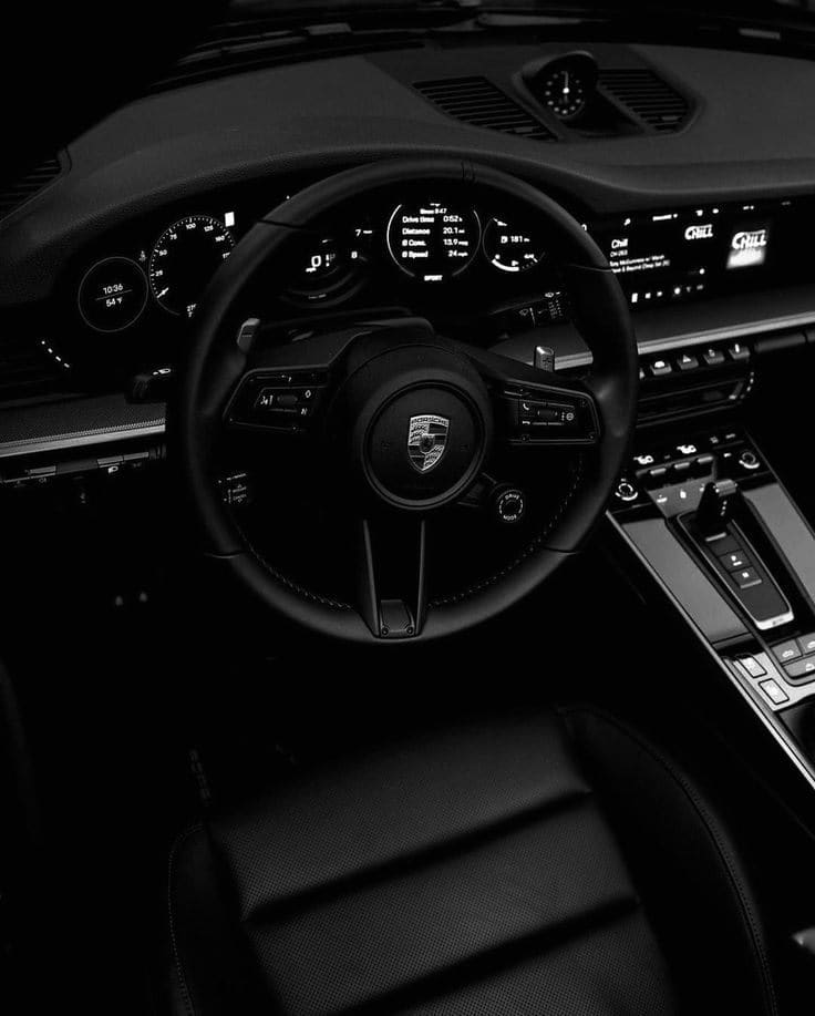 Habitacle cuir noir d'une Porsche 911 remis à neuf, volant et écrans impeccables